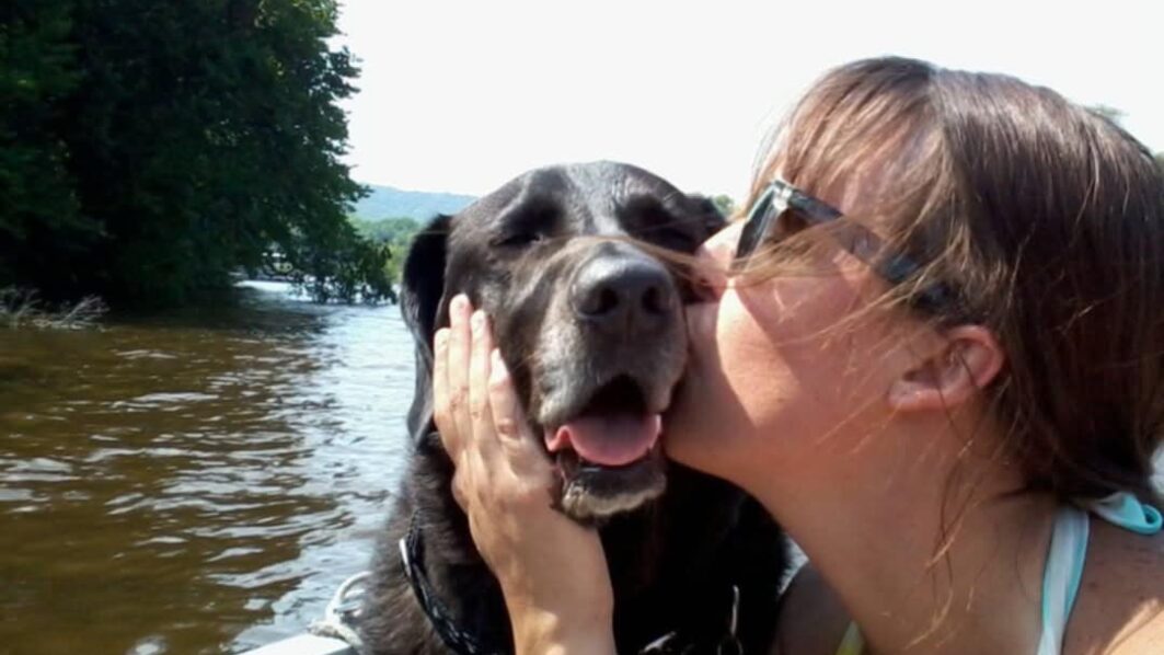 While boating on the Mississippi River, Megan gives kisses to one of her many rescue dogs, Kota, who has since passed away. Photo courtesy Megan