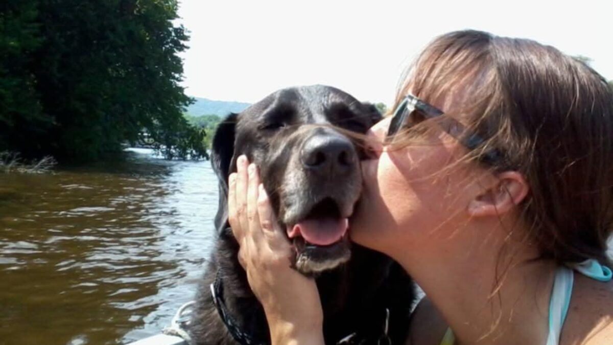 While boating on the Mississippi River, Megan gives kisses to one of her many rescue dogs, Kota, who has since passed away. Photo courtesy Megan