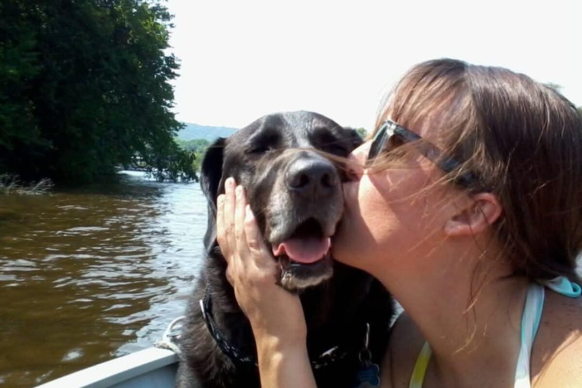 While boating on the Mississippi River, Megan gives kisses to one of her many rescue dogs, Kota, who has since passed away. Photo courtesy Megan