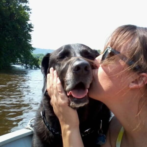 While boating on the Mississippi River, Megan gives kisses to one of her many rescue dogs, Kota, who has since passed away. Photo courtesy Megan