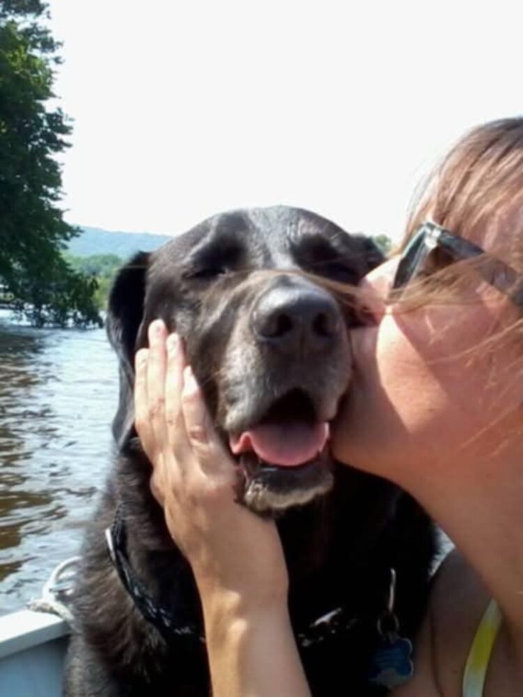 While boating on the Mississippi River, Megan gives kisses to one of her many rescue dogs, Kota, who has since passed away. Photo courtesy Megan