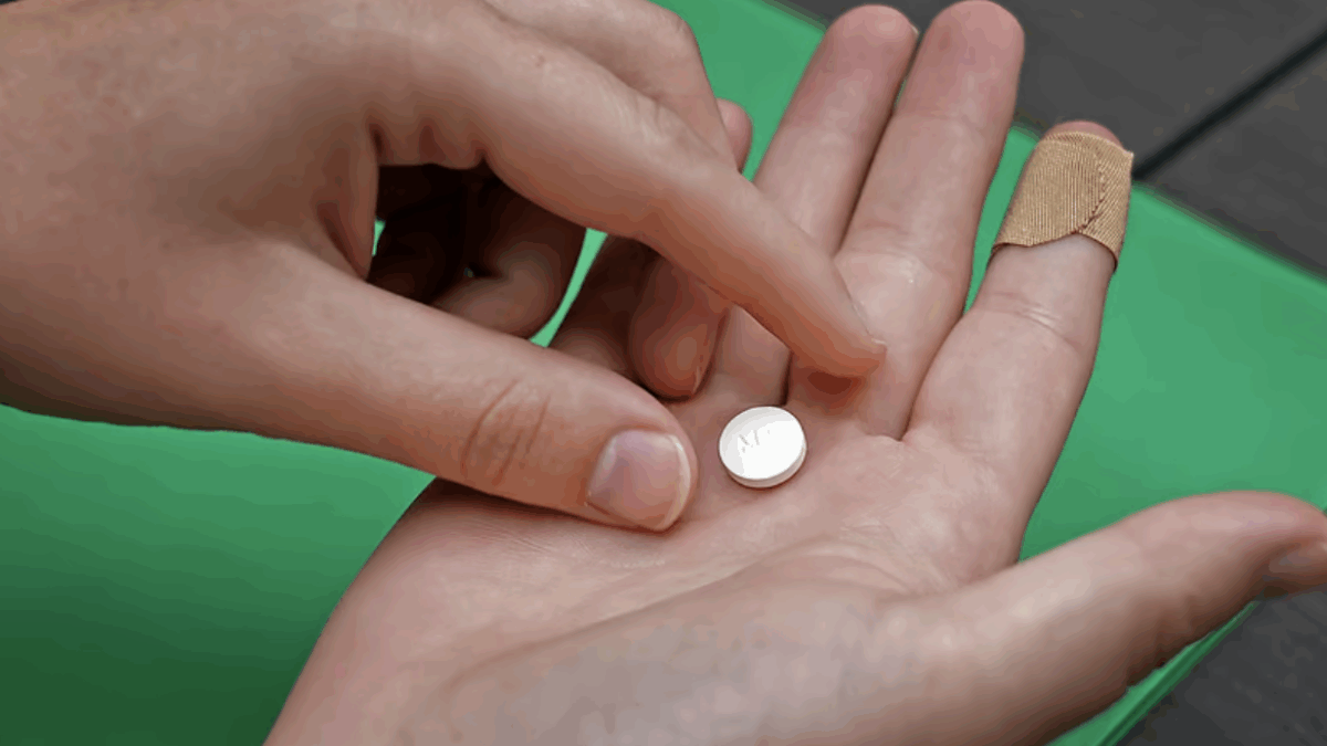 A patient prepares to take the first of two pills for a medication abortion during a visit to a clinic in Kansas City, Kan., on Oct. 12, 2022. (Charlie Riedel/AP)