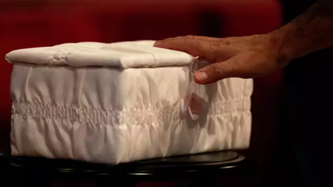 A man touches the casket of "Baby Mary" at a funeral service on San Antonio's Northwest Side. The mother had been accused of flushing the baby down a Whataburger toilet, causing injuries to her head. Authorities later determined that the woman had a miscarriage, not a live birth, and had not tried to flush the fetus down the toilet. Credit: Jessica Phelps