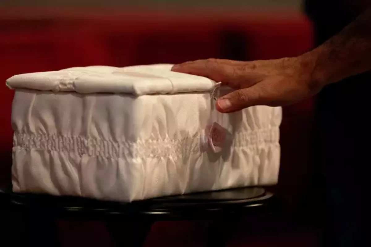 A man touches the casket of "Baby Mary" at a funeral service on San Antonio's Northwest Side. The mother had been accused of flushing the baby down a Whataburger toilet, causing injuries to her head. Authorities later determined that the woman had a miscarriage, not a live birth, and had not tried to flush the fetus down the toilet. Credit: Jessica Phelps
