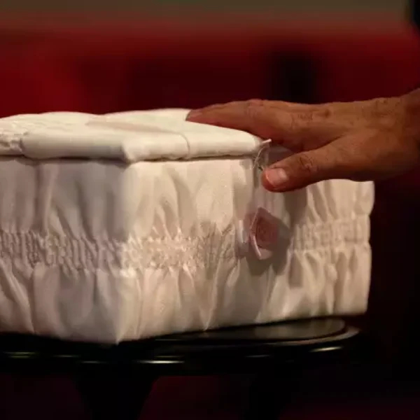 A man touches the casket of "Baby Mary" at a funeral service on San Antonio's Northwest Side. The mother had been accused of flushing the baby down a Whataburger toilet, causing injuries to her head. Authorities later determined that the woman had a miscarriage, not a live birth, and had not tried to flush the fetus down the toilet. Credit: Jessica Phelps