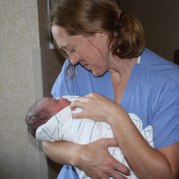 Dr. Becky Uranga, an OB-GYN in the Boise area of Idaho, holds one of many babies she has delivered over her 14 years of practice. As OB-GYNs and specialists have left Idaho after the implementation of a near-total abortion ban, Uranga said she is shouldering more work and feeling unable to give as much of her attention to some patients as she used to. (Courtesy of Dr. Becky Uranga)